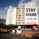 A man walks past a poster covering the side of a building ahead of a 21 day lockdown aimed at limiting the spread of coronavirus disease (COVID-19), in Cape Town, South Africa, Mar. 26, 2020.